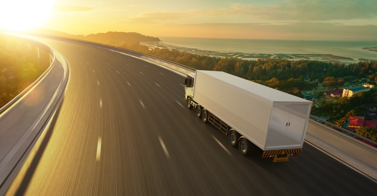 Freight truck driving on a highway at sunrise